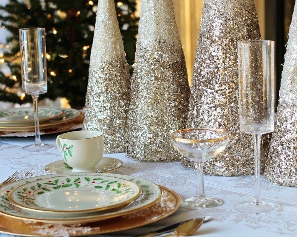 A table set for Christmas dinner with festive decorations and tableware.