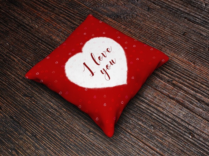 A red and white throw pillow with "I love you" written on it.