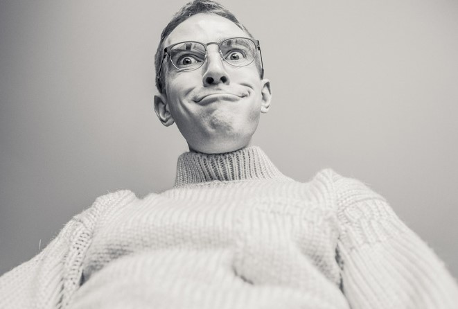 A man in a sweater making a funny face at the camera.