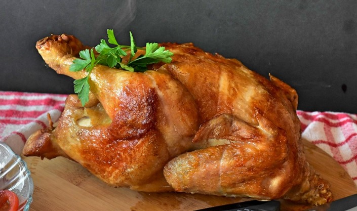 A whole roast chicken on a cutting board.